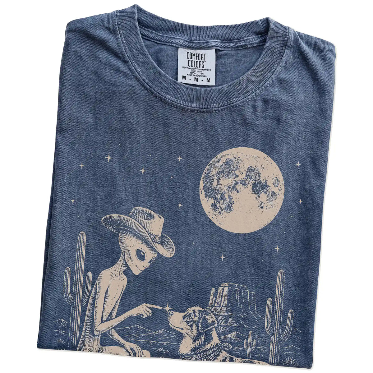 Folded Denim Comfort Colors® T-shirt showing cowboy alien fist-bumping a australian shepherd beneath the moon