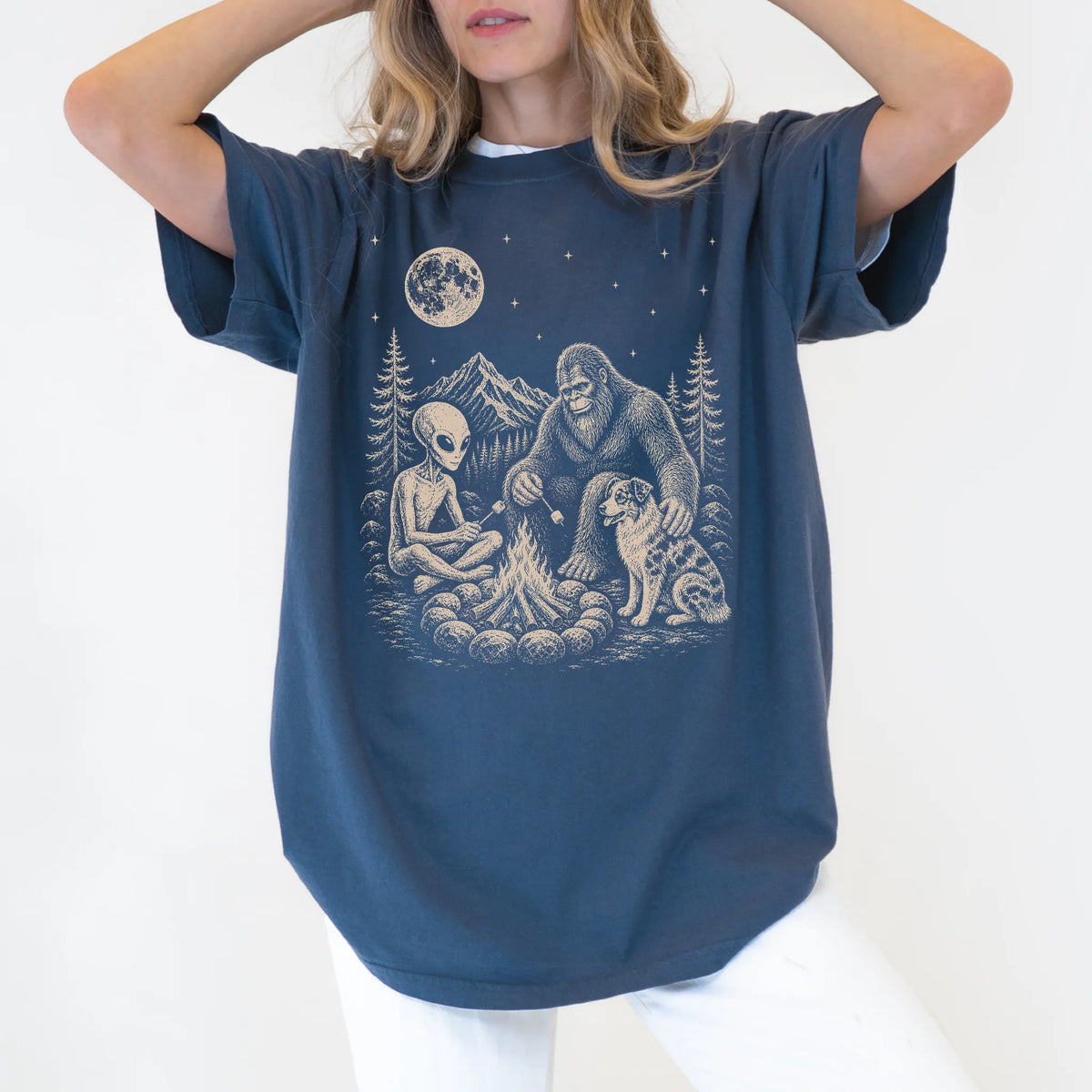 Model wearing a Denim Comfort Colors® T-shirt showing Australian Shepherd camping with Bigfoot and an alien