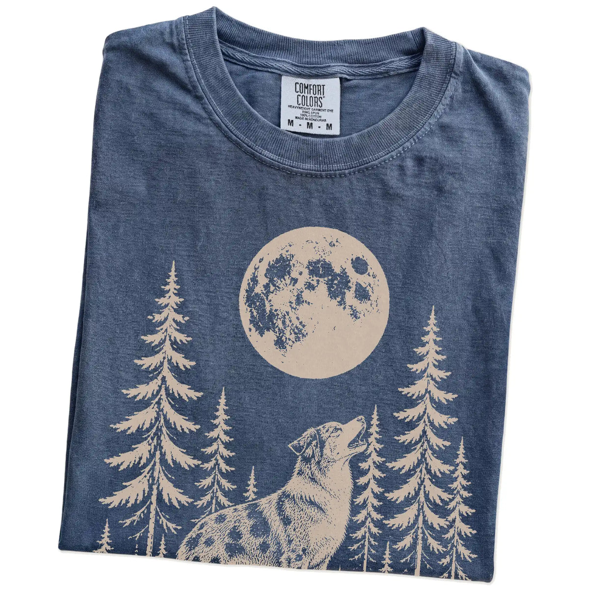 Folded Denim Comfort Colors® T-shirt showing a Australian Shepherd howling beneath the moon and pine trees