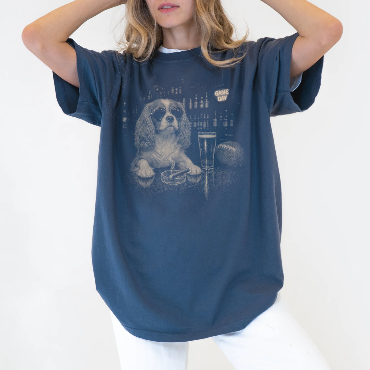 Model wearing a Denim Comfort Colors® T-shirt featuring Cavalier King Charles Spaniel with beer and football graphics