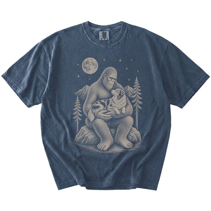 Denim T-shirt with Bigfoot holding an Australian Shepherd under a moonlit sky