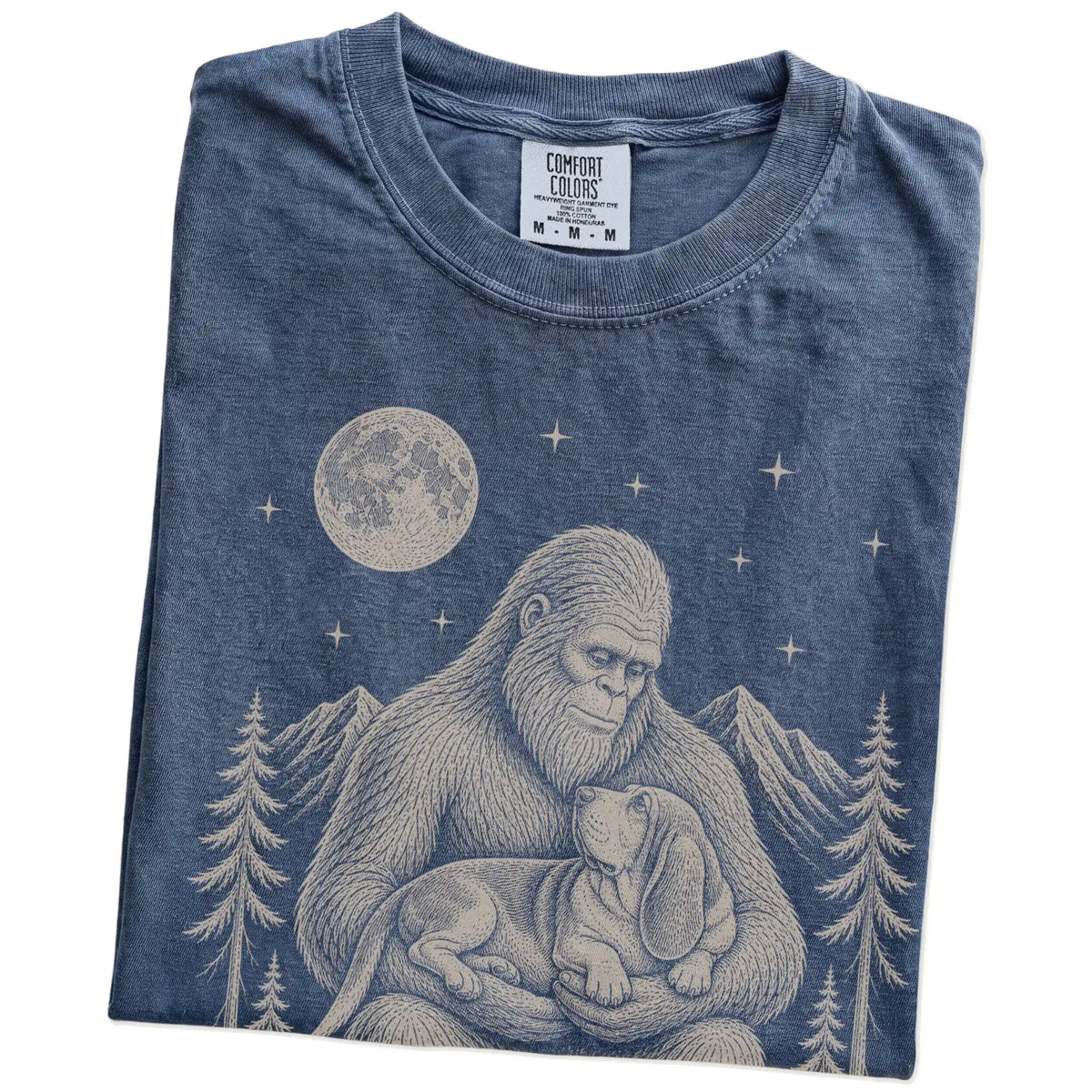 Folded Denim Comfort Colors® T-shirt showing Bigfoot holding a Basset Hound