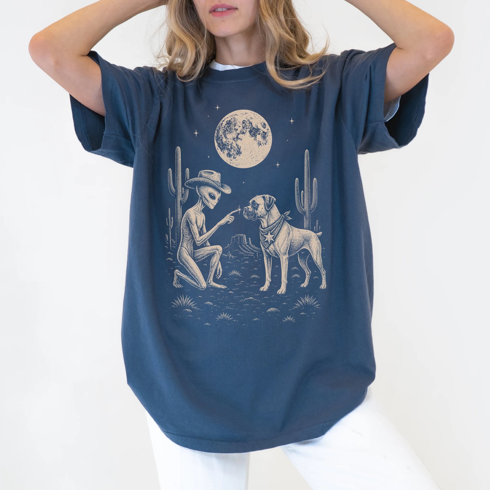 Model wearing a Denim Comfort Colors® T-shirt with cowboy alien fist-bumping a boxer beneath the moon