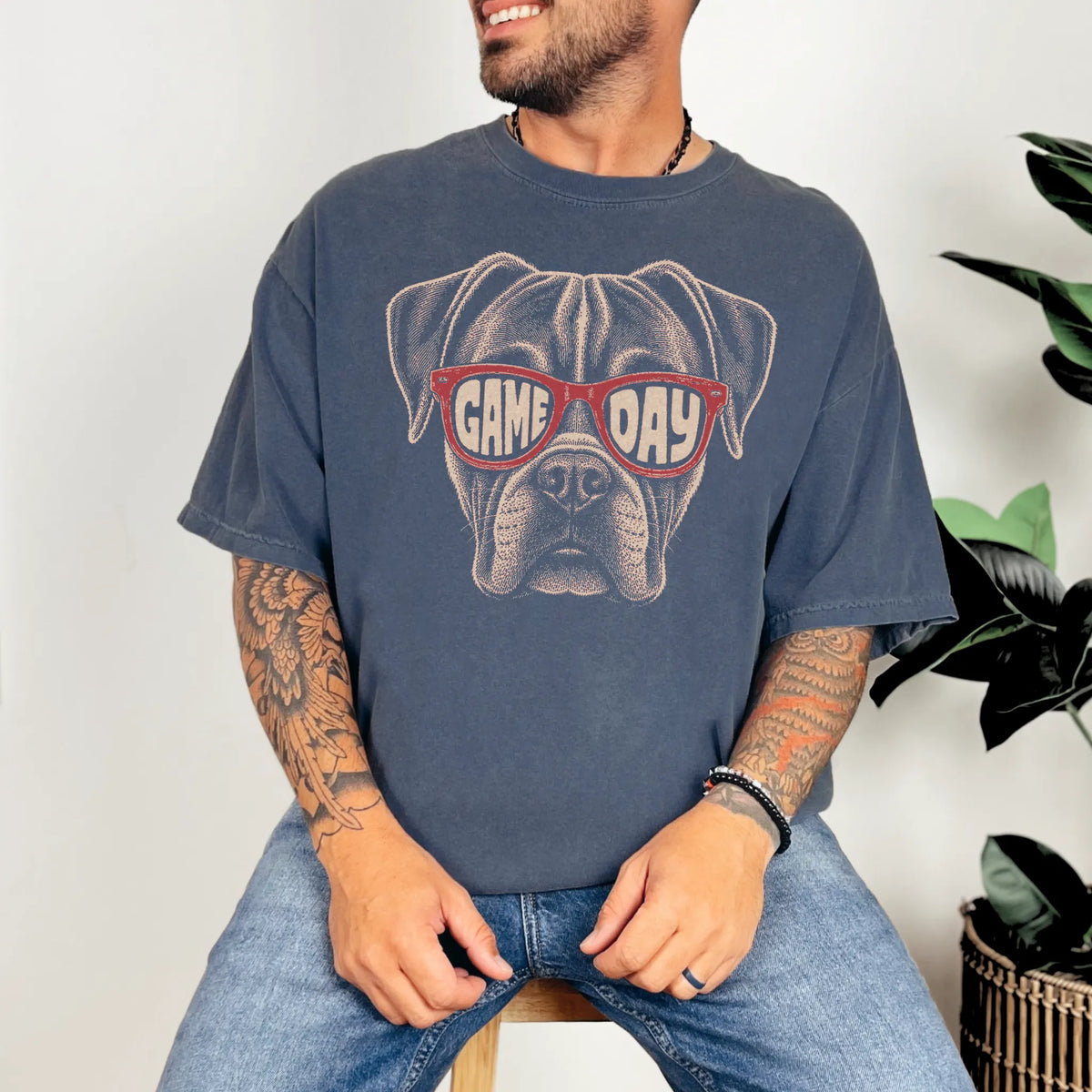 Model wearing a Denim Comfort Colors® T-shirt with boxer wearing red game day sunglasses