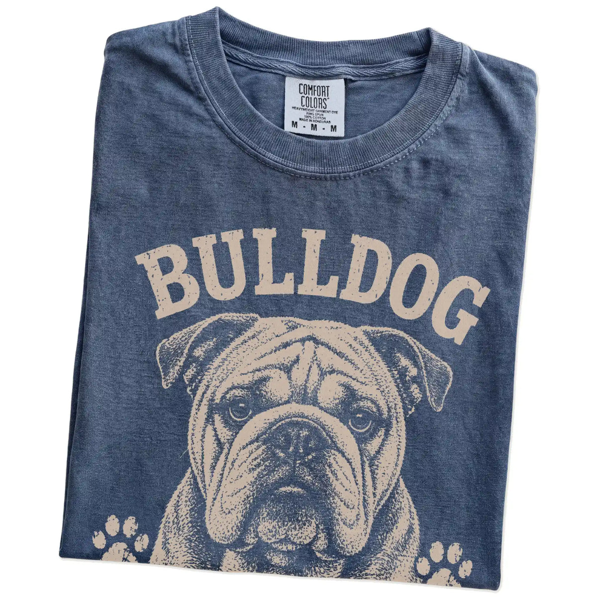 Folded Denim Comfort Colors® T-shirt showing Bulldog design with “Built Tough, Runs On Snacks” lettering
