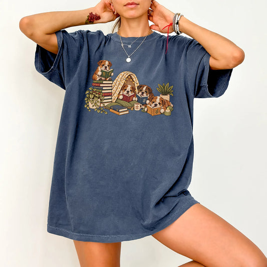 Bulldog puppies reading books in a cozy blanket fort on a Denim T-shirt worn by a model