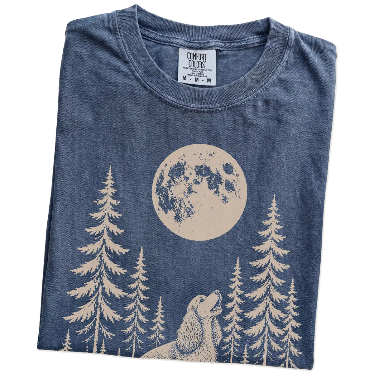 Folded Denim Comfort Colors® T-shirt showing a Cocker Spaniel howling beneath the moon and pine trees