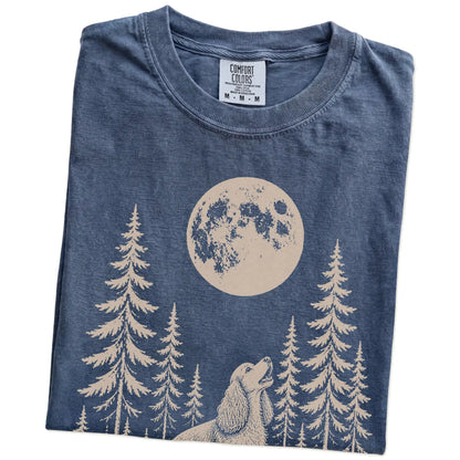 Folded Denim Comfort Colors® T-shirt showing a Cocker Spaniel howling beneath the moon and pine trees