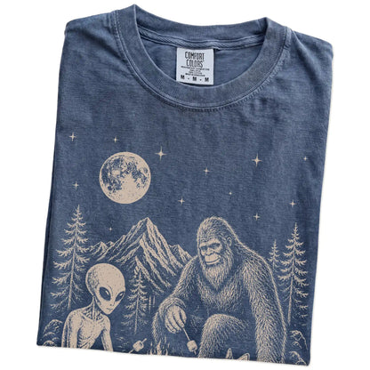 Folded Denim Comfort Colors® T-shirt showing Corgi camping with Bigfoot and an alien