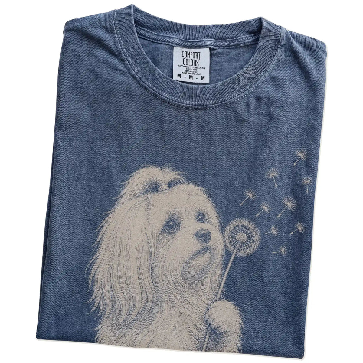 Folded Denim Comfort Colors® T-shirt showing Maltese portrait with drifting dandelion seeds