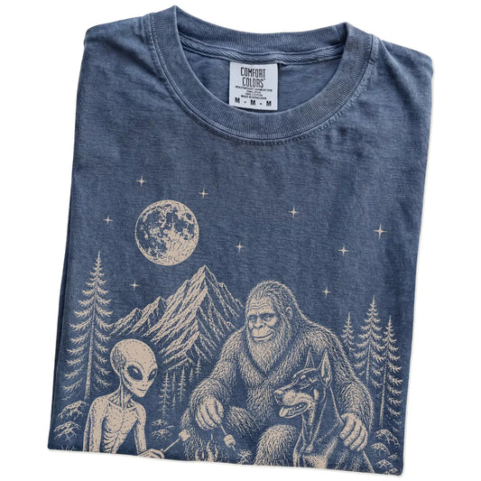 Folded Denim Comfort Colors® T-shirt showing Doberman camping with Bigfoot and an alien