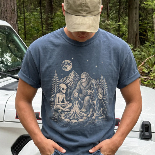 Model wearing a Denim Comfort Colors® T-shirt showing Doberman camping with Bigfoot and an alien