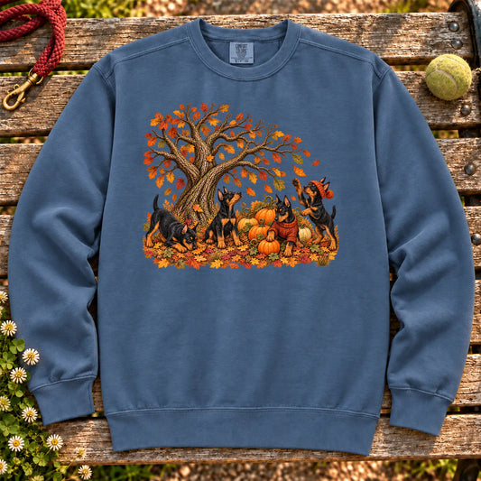 Four Doberman puppies with pumpkins beneath an autumn tree on a Denim garment-dyed sweatshirt