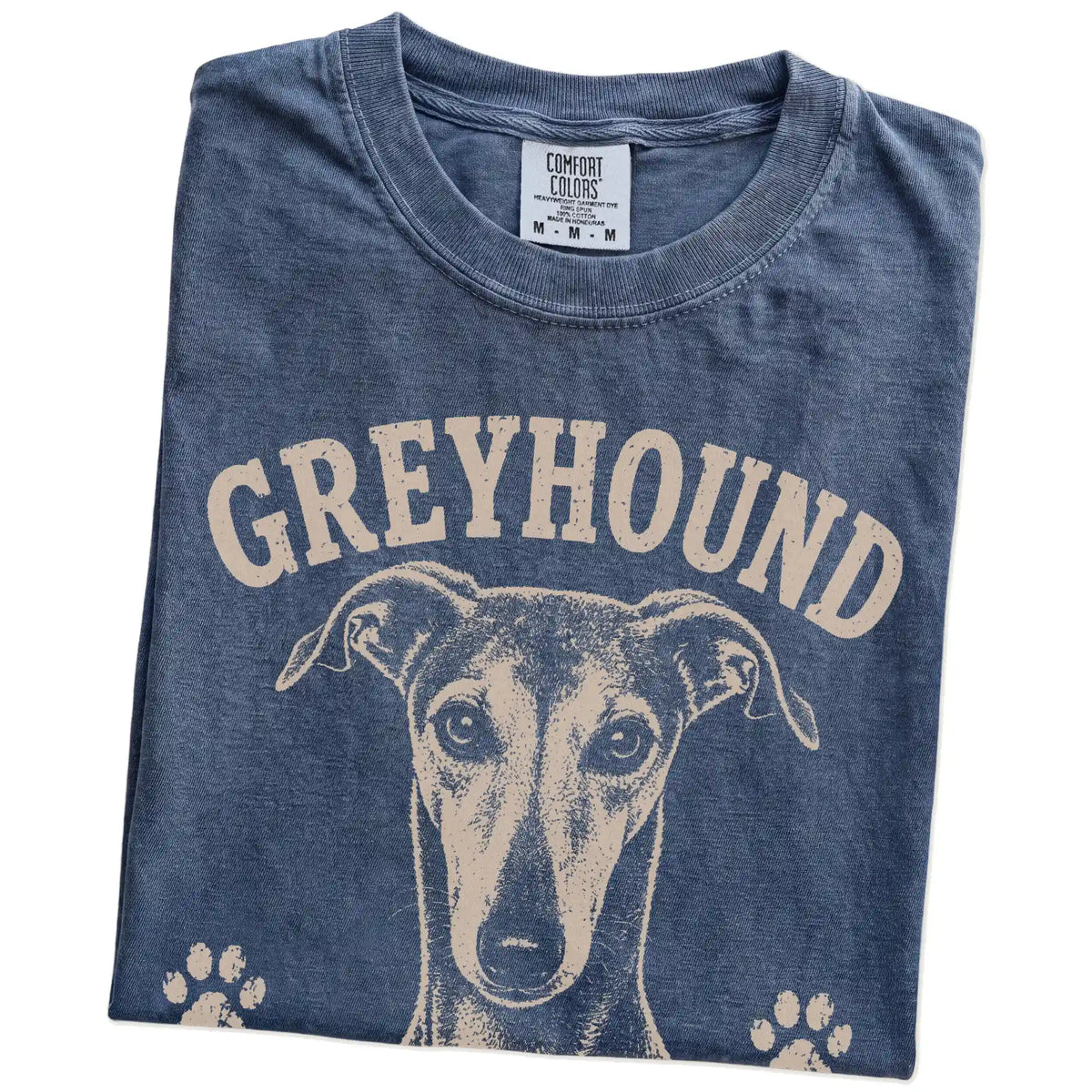 Folded Denim Comfort Colors® T-shirt showing Greyhound design with “Fast When Necessary, Lazy By Choice” lettering