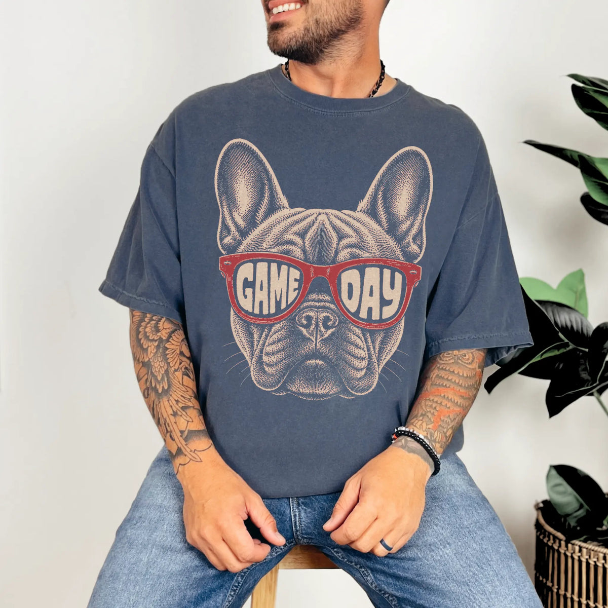 Model wearing a Denim Comfort Colors® T-shirt with french bulldog wearing red game day sunglasses