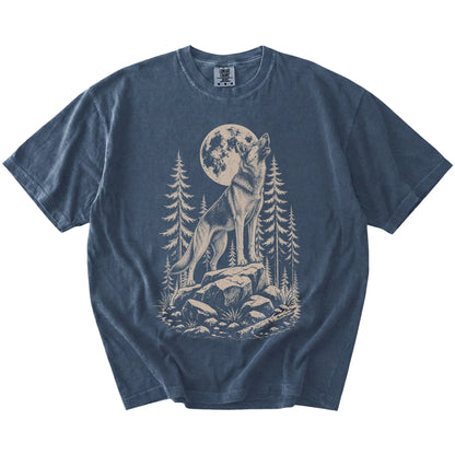 German Shepherd howling beneath the moon and pine trees on a Denim Comfort Colors® T-shirt