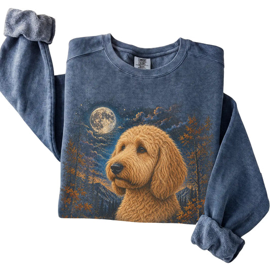 Folded denim sweatshirt with Goldendoodle Autumn Moon artwork.