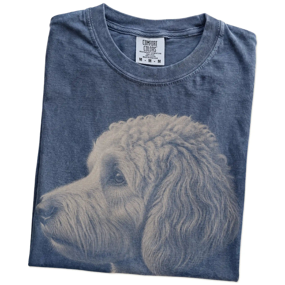 Folded Denim Comfort Colors® T-shirt showing a detailed photographic portrait of a Goldendoodle
