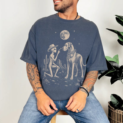 Model wearing a Denim Comfort Colors® T-shirt with cowboy alien fist-bumping a great dane beneath the moon