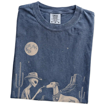 Folded Denim Comfort Colors® T-shirt showing cowboy alien fist-bumping a greyhound beneath the moon