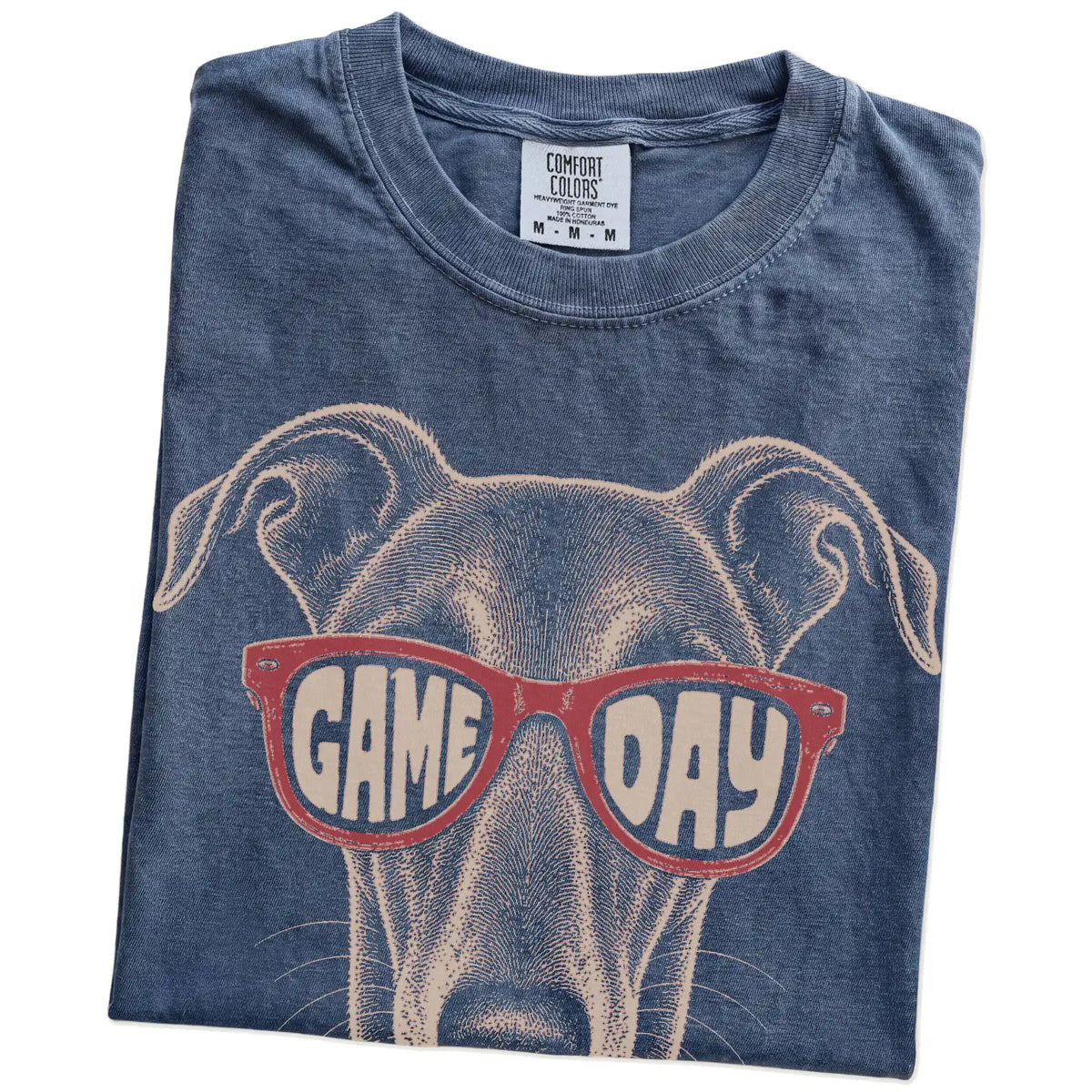 Folded Denim Comfort Colors® T-shirt showing greyhound wearing red game day sunglasses