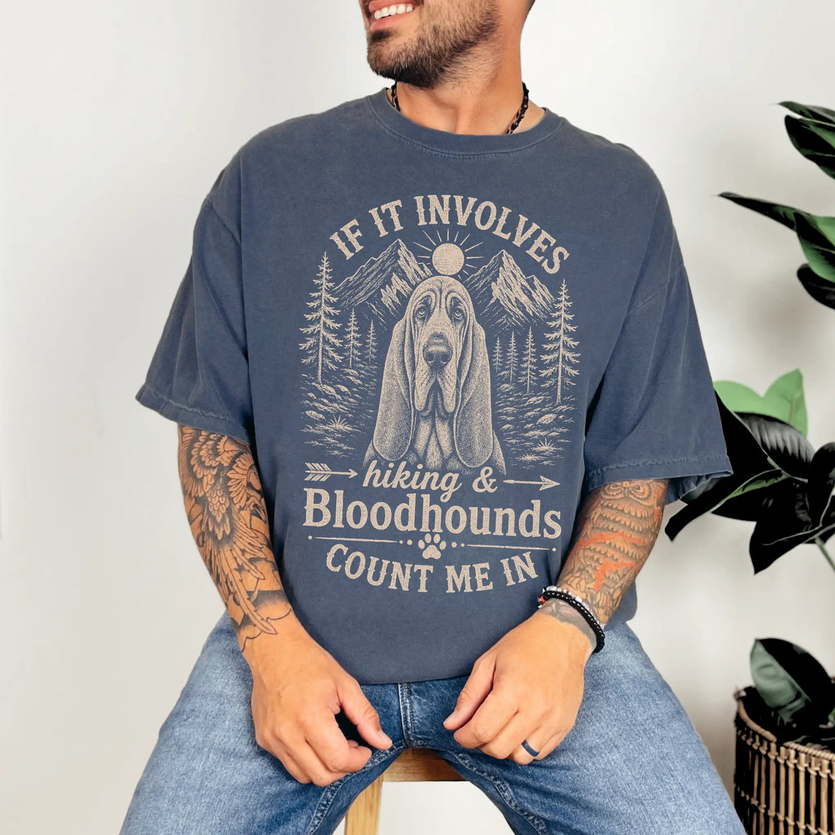 Model wearing a Denim Comfort Colors® T-shirt featuring Bloodhound hiking design with mountain scenery
