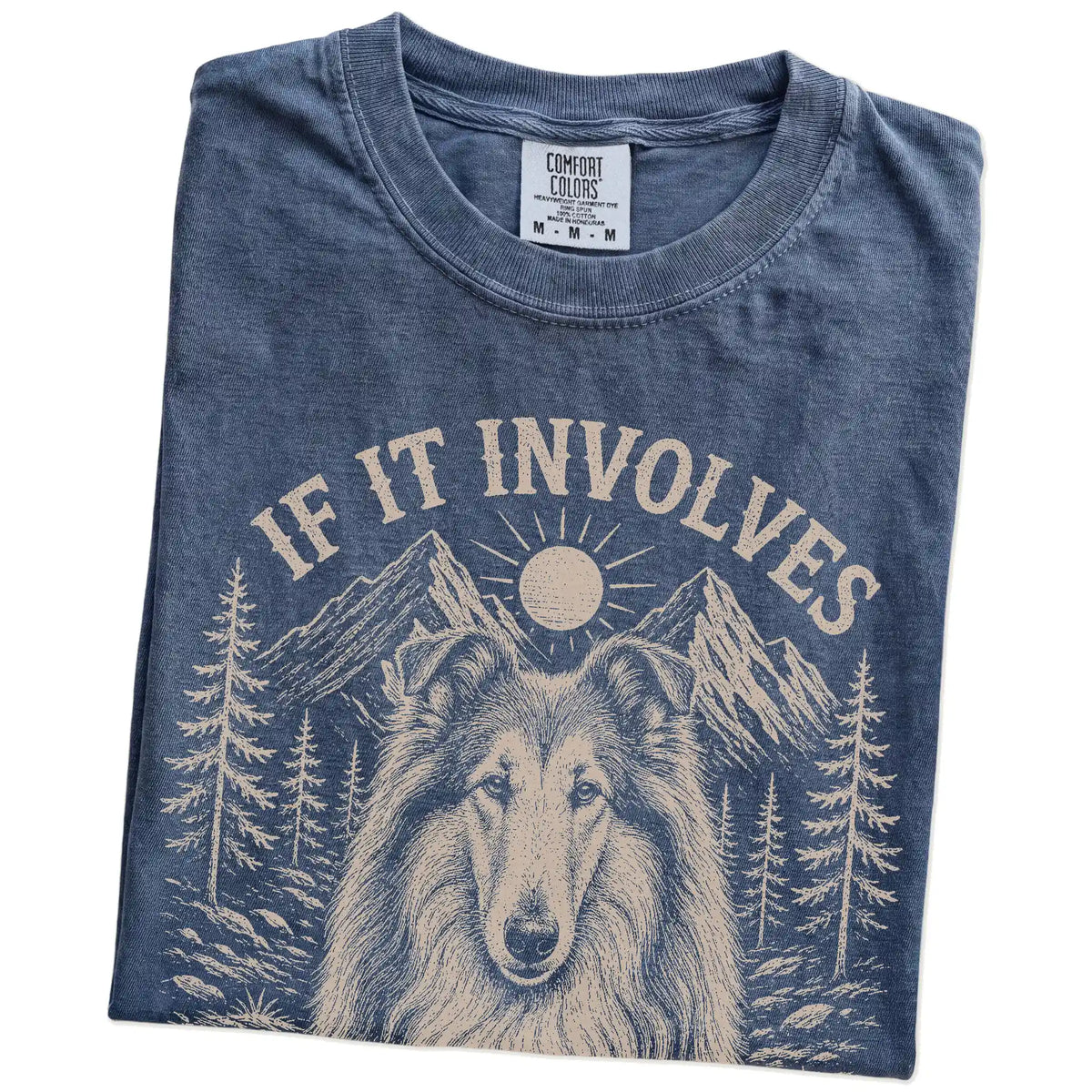 Folded Denim Comfort Colors® T-shirt showing Collie hiking design with mountain scenery