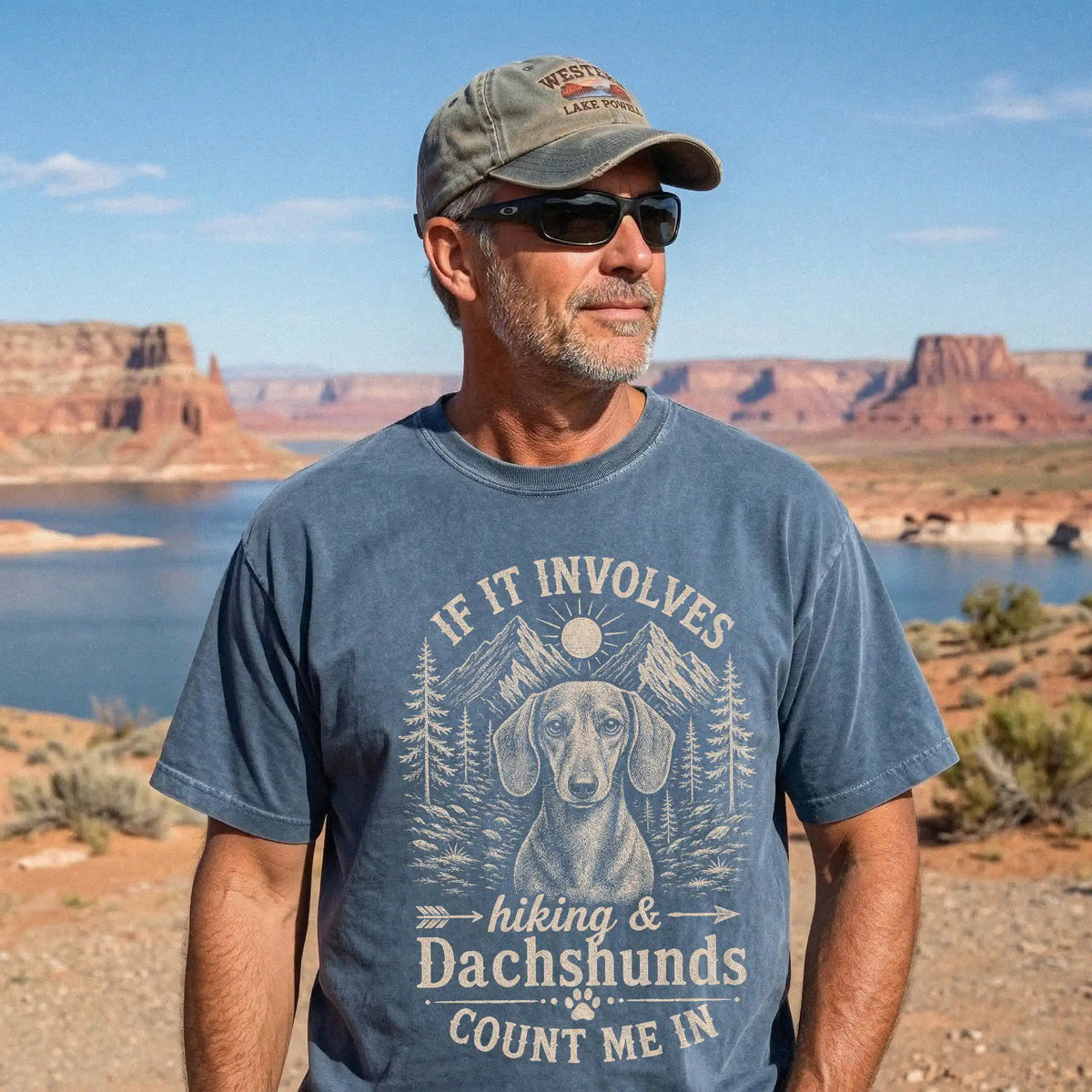 Model wearing a Denim Comfort Colors® T-shirt featuring Dachshund hiking design with mountain scenery