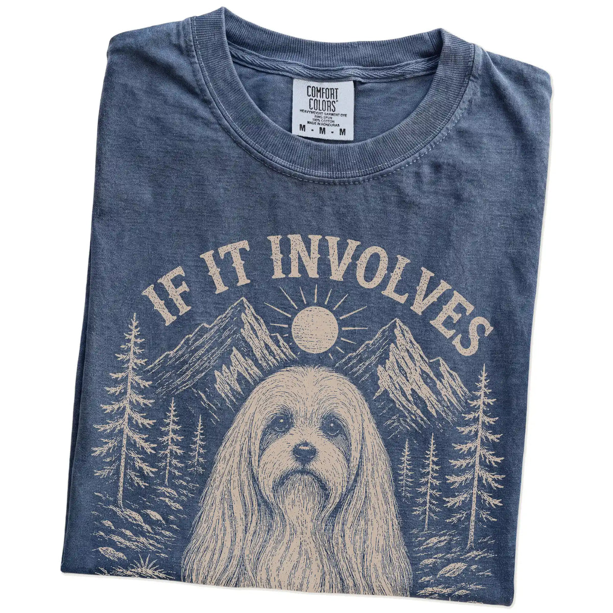 Folded Denim Comfort Colors® T-shirt showing Maltese hiking design with mountain scenery