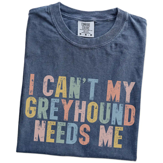 Folded Denim Comfort Colors® T-shirt showing Greyhound with “I Can’t, My Dog Needs Me” lettering