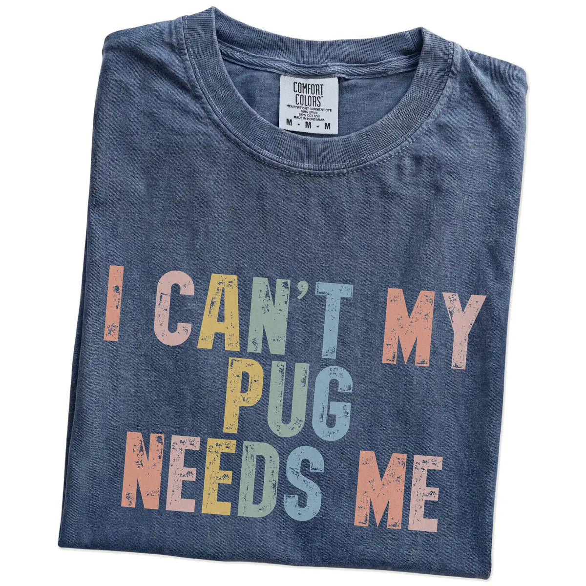 Folded Denim Comfort Colors® T-shirt showing Pug with “I Can’t, My Dog Needs Me” lettering