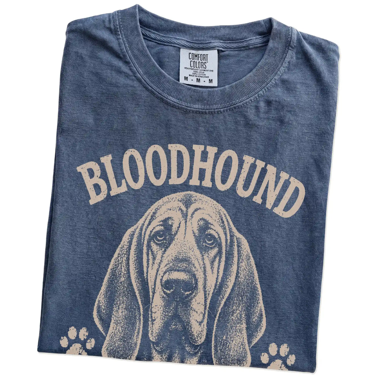 Folded Denim Comfort Colors® T-shirt showing Bloodhound design with “I Never Forget A Scent Or A Grudge” lettering