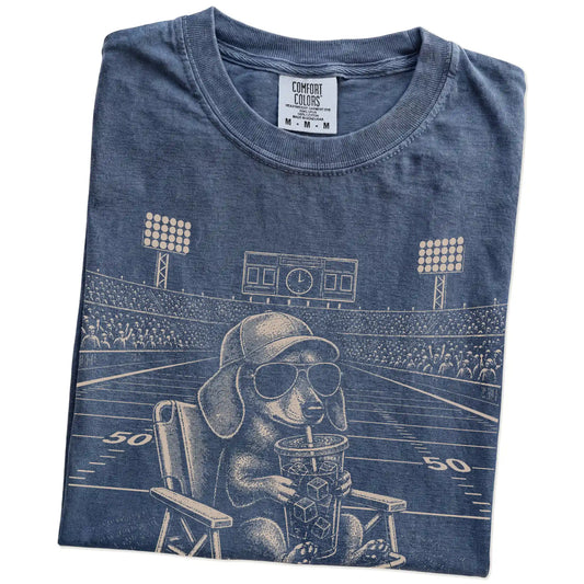 Folded Denim Comfort Colors® T-shirt showing Dachshund claiming the football field with “I Live Here Now” lettering
