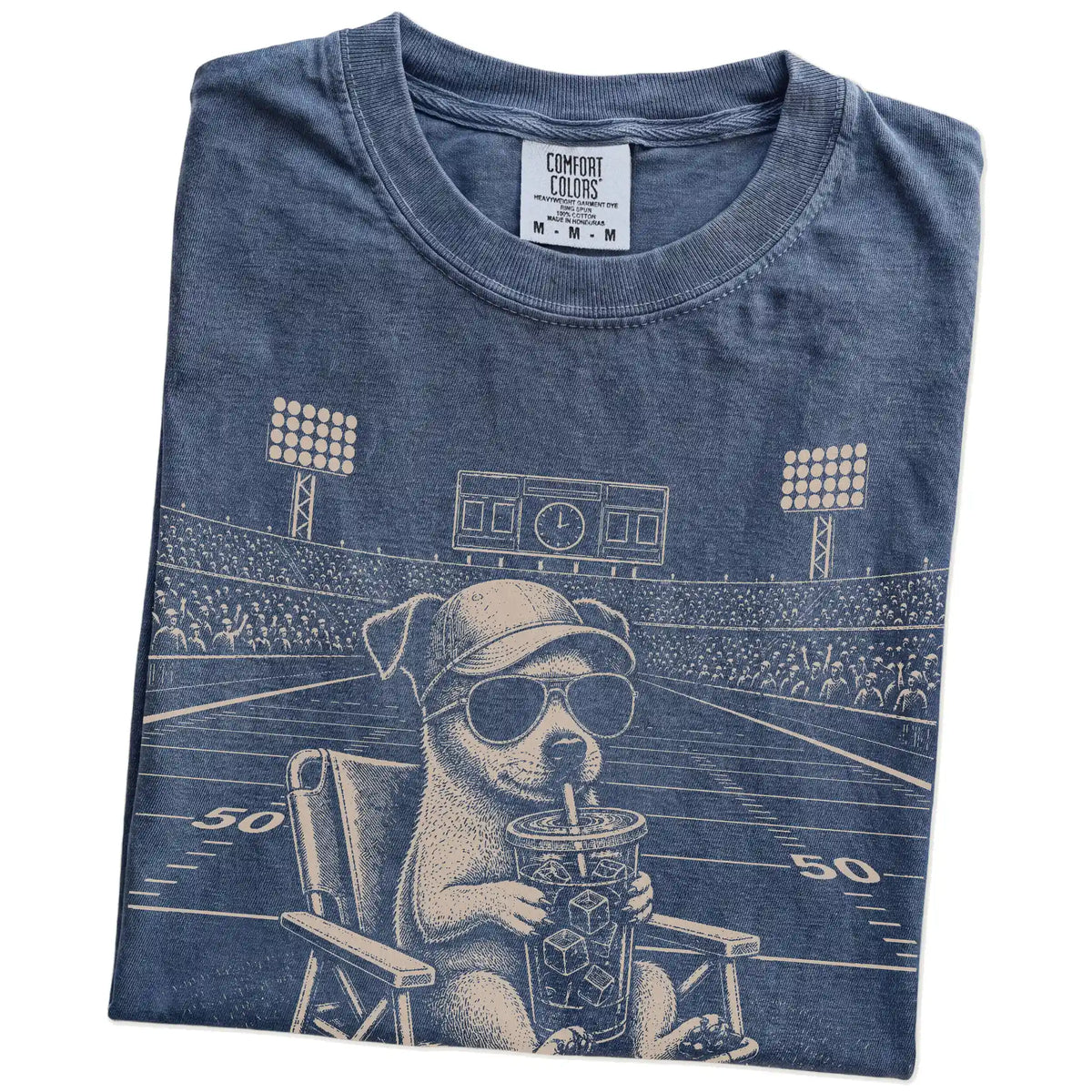 Folded Denim Comfort Colors® T-shirt showing Jack Russell claiming the football field with “I Live Here Now” lettering