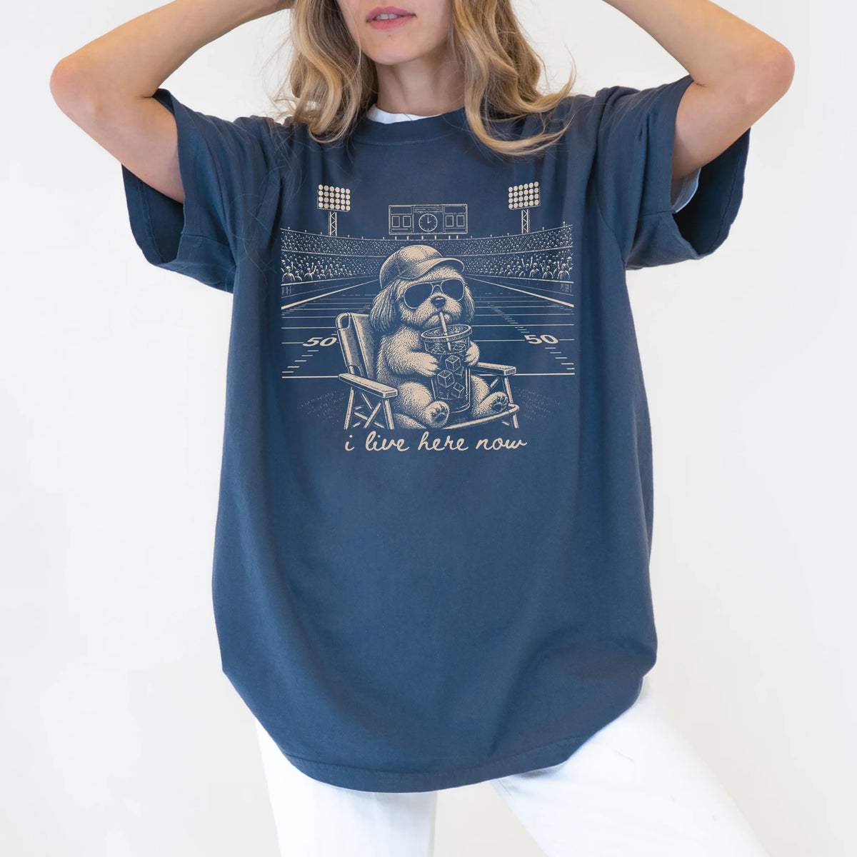 Model wearing a Denim Comfort Colors® T-shirt featuring Shih Tzu claiming the football field with “I Live Here Now” lettering