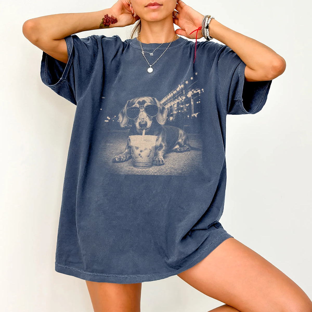 Model wearing a Denim Comfort Colors® T-shirt featuring Dachshund with iced coffee in a retro grunge design