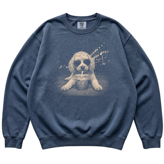 Goldendoodle wearing aviator sunglasses and drinking iced coffee on a Denim Comfort Colors 1566 Sweatshirt, flat lay view