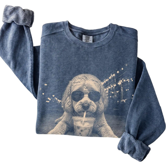 Labradoodle wearing aviator sunglasses and drinking iced coffee on a Denim Comfort Colors 1566 Sweatshirt, folded view