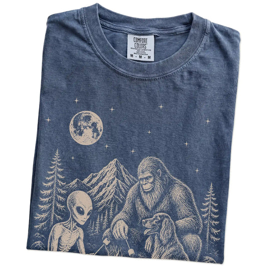 Folded Denim Comfort Colors® T-shirt showing Irish Setter camping with Bigfoot and an alien