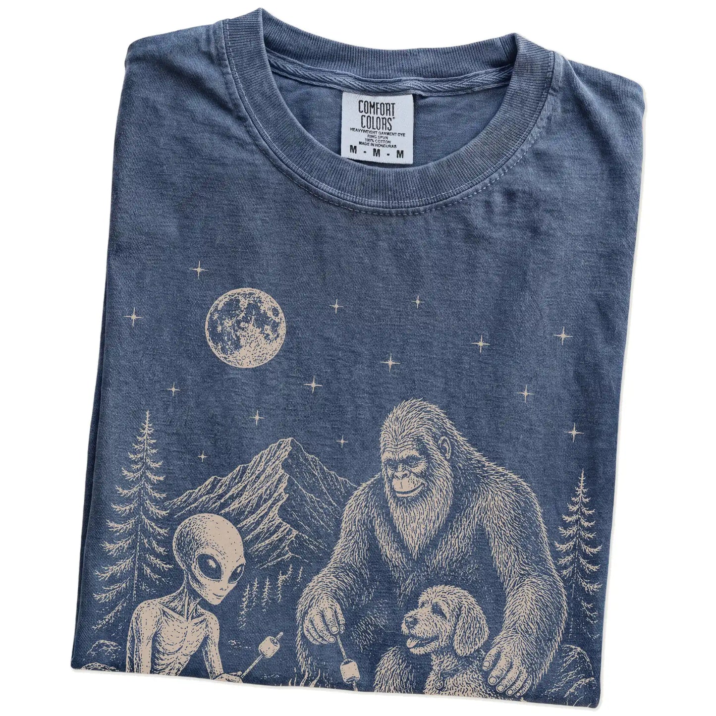 Folded Denim Comfort Colors® T-shirt showing Labradoodle camping with Bigfoot and an alien