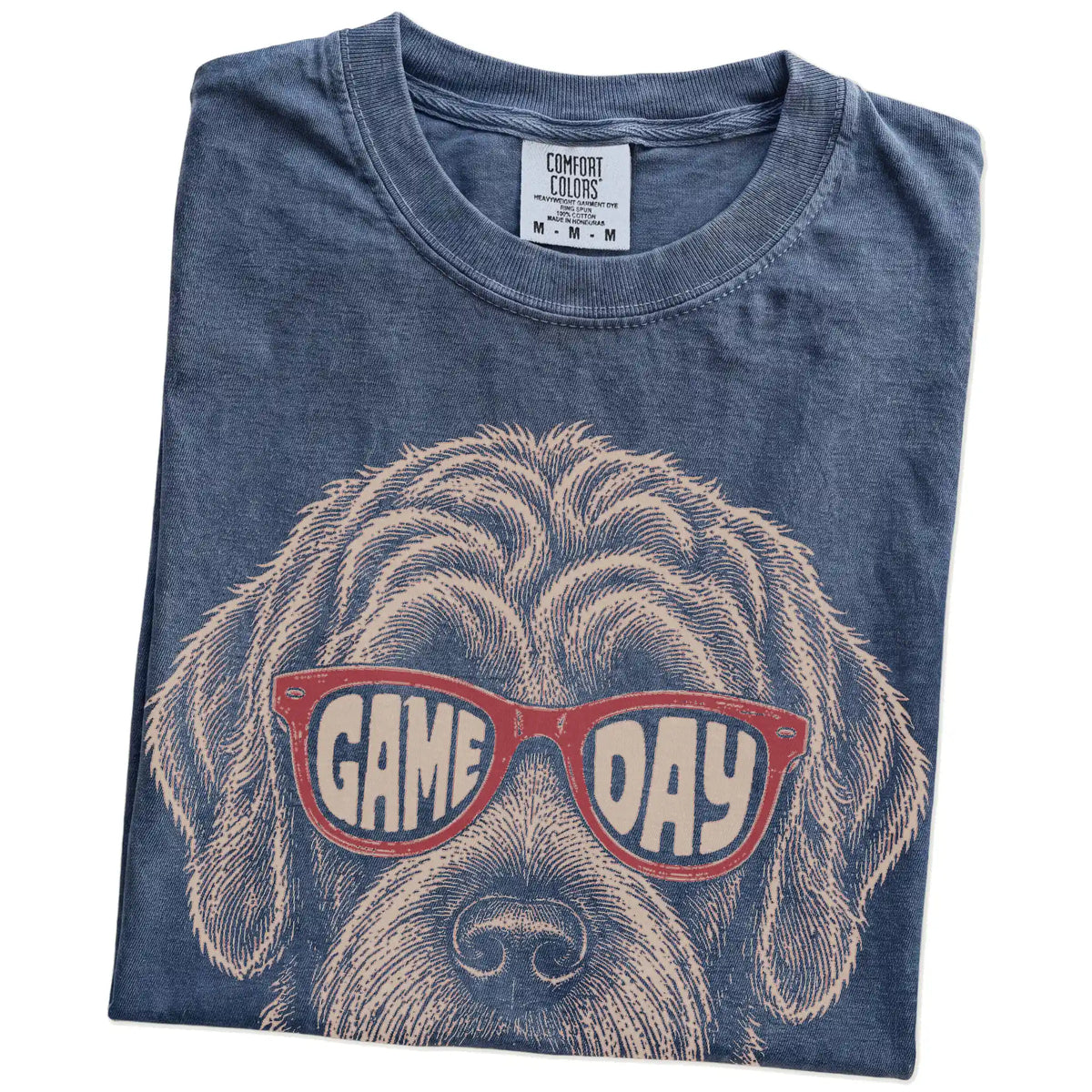 Folded Denim Comfort Colors® T-shirt showing labradoodle wearing red game day sunglasses
