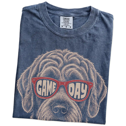 Folded Denim Comfort Colors® T-shirt showing labradoodle wearing red game day sunglasses