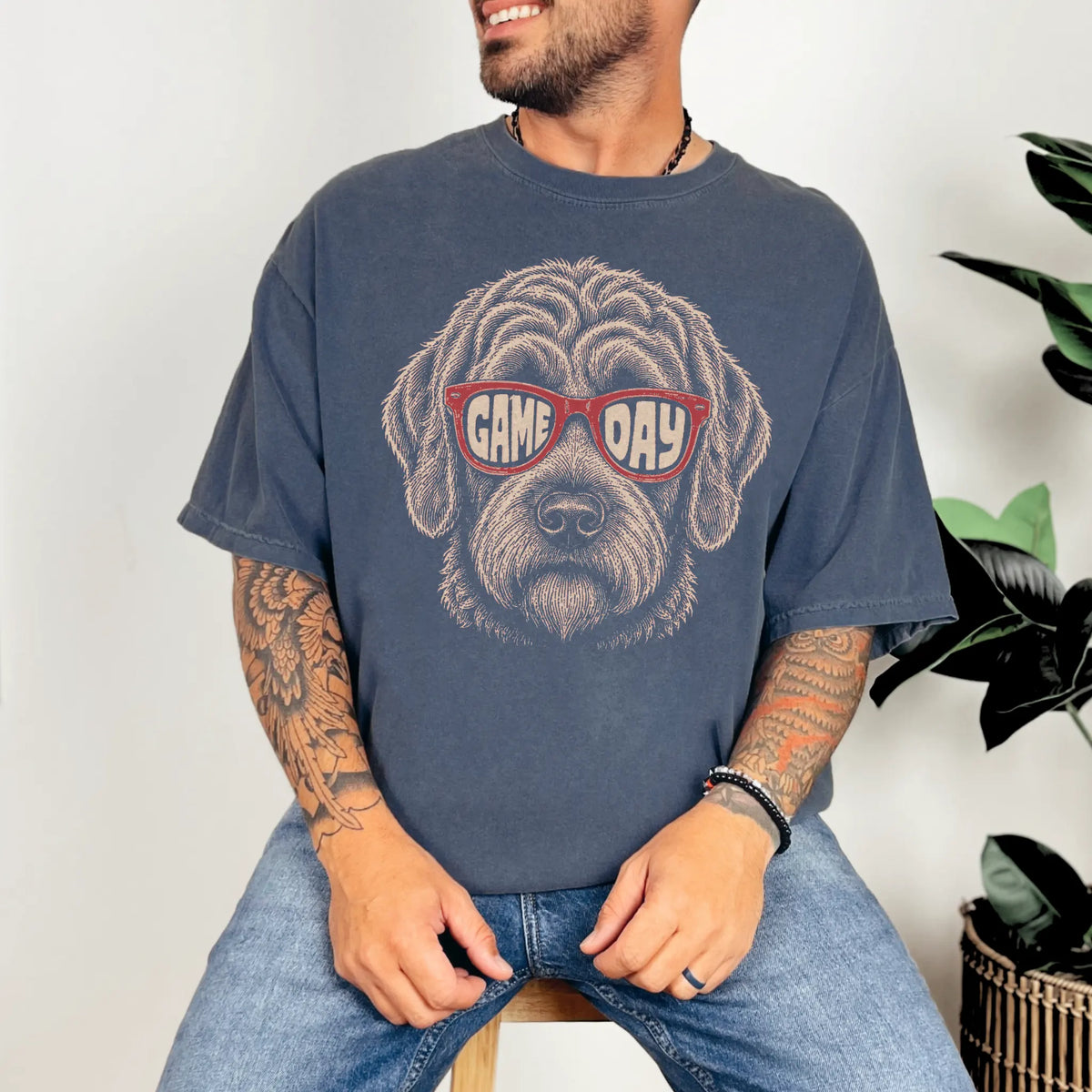 Model wearing a Denim Comfort Colors® T-shirt with labradoodle wearing red game day sunglasses