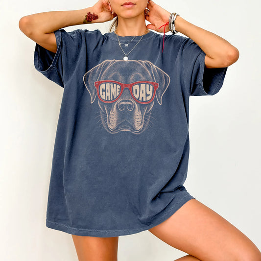 Model wearing a Denim Comfort Colors® T-shirt with labrador retriever wearing red game day sunglasses