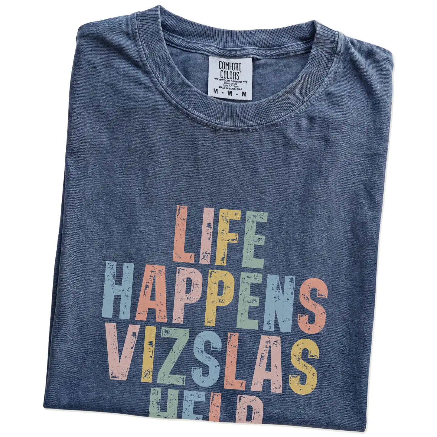 Folded Denim Comfort Colors® T-shirt showing retro “Life Happens, Vizslas Help” lettering