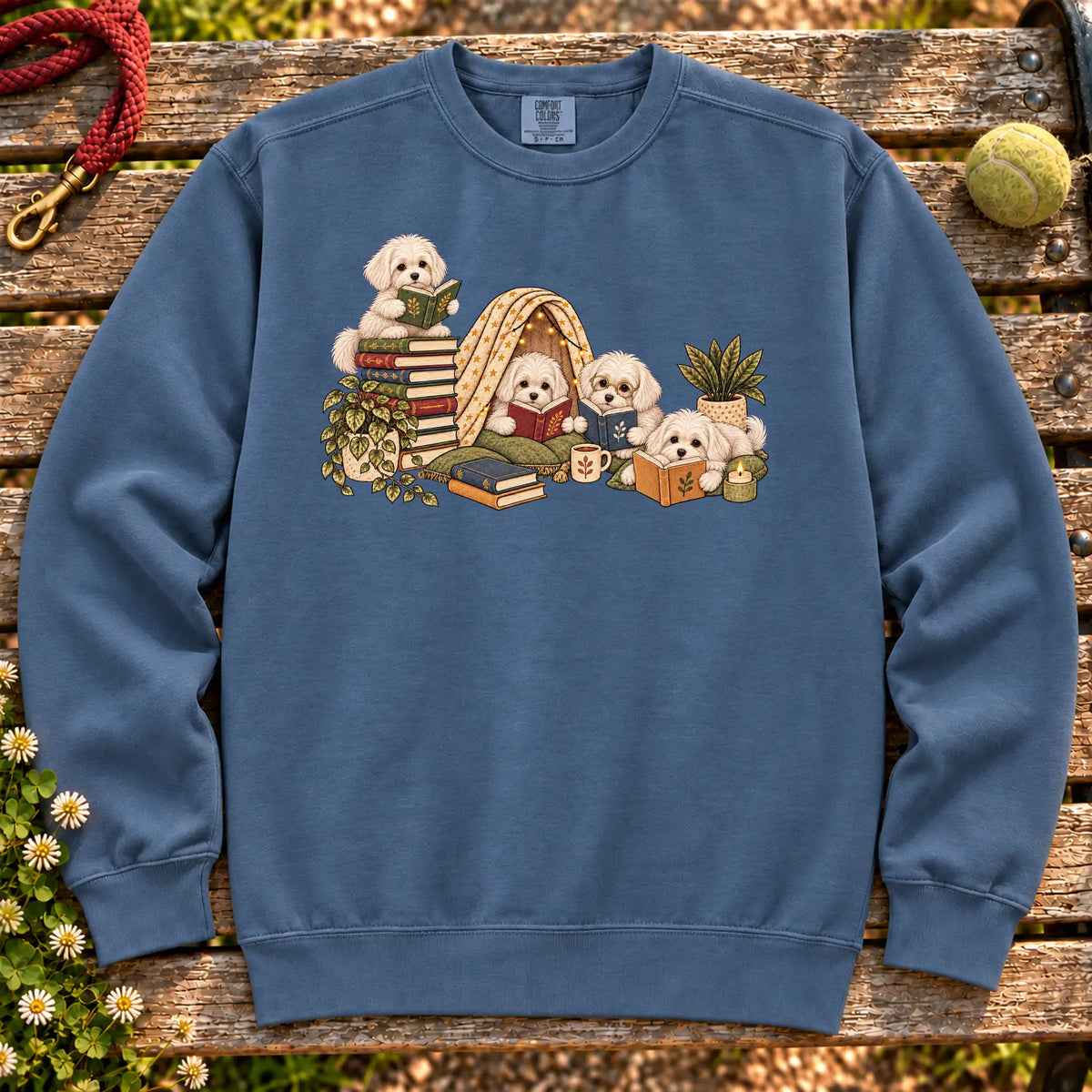 Maltese puppies reading books in a cozy blanket fort on a Denim sweatshirt