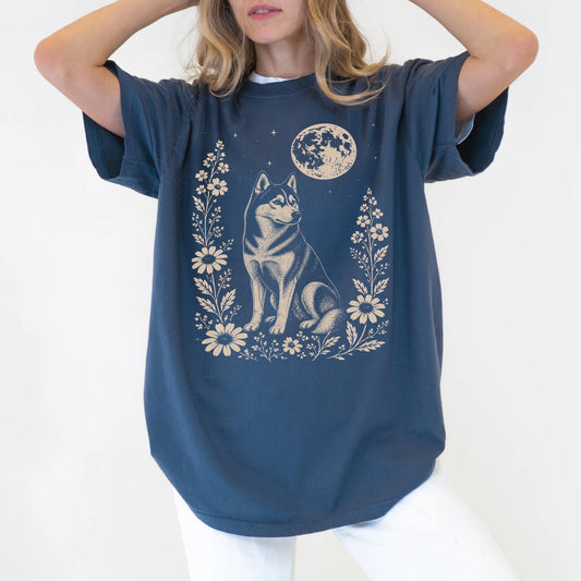 Model wearing a Denim Comfort Colors® T-shirt featuring Husky framed by flowers beneath the moon