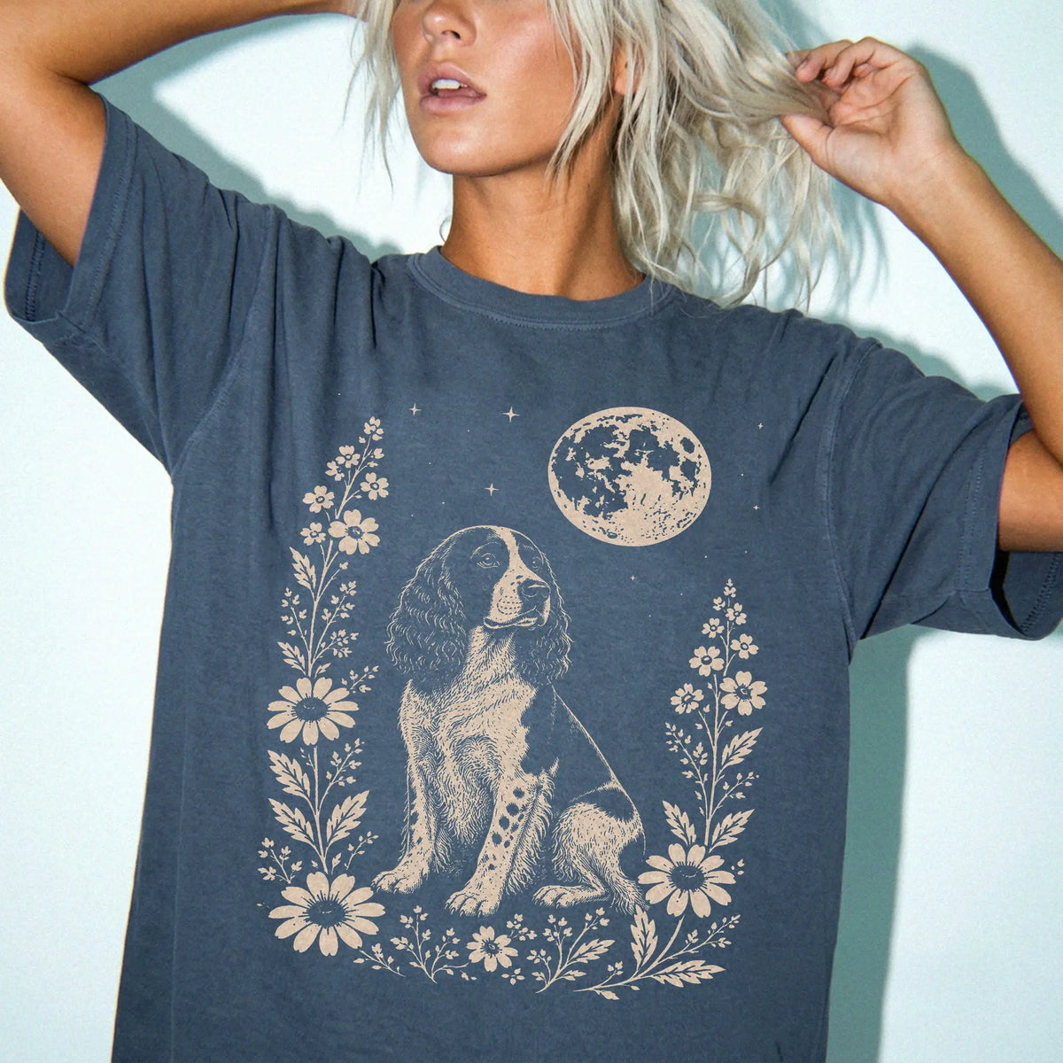 Model wearing a Denim Comfort Colors® T-shirt featuring Springer Spaniel framed by flowers beneath the moon