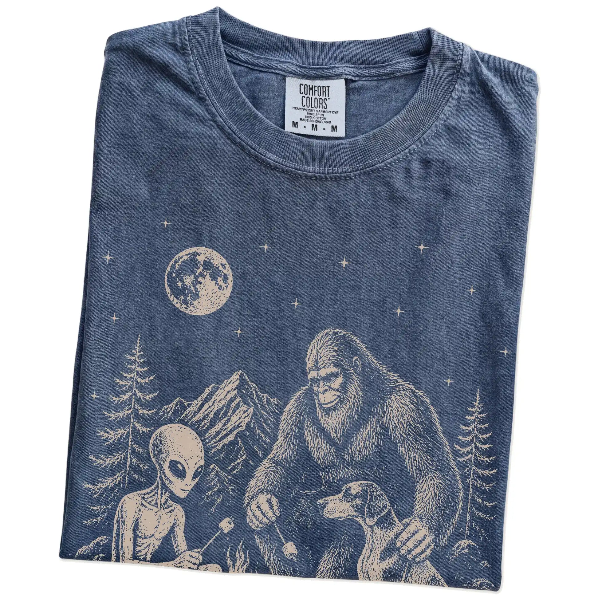 Folded Denim Comfort Colors® T-shirt showing Pointer camping with Bigfoot and an alien