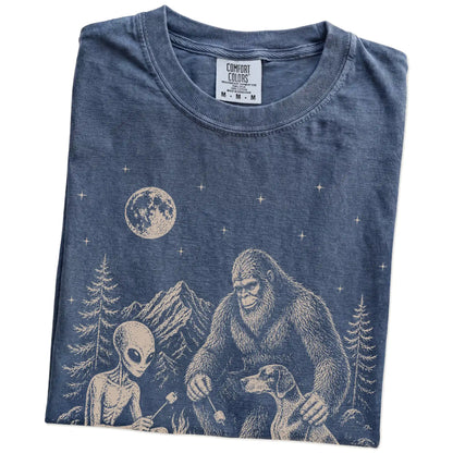 Folded Denim Comfort Colors® T-shirt showing Pointer camping with Bigfoot and an alien